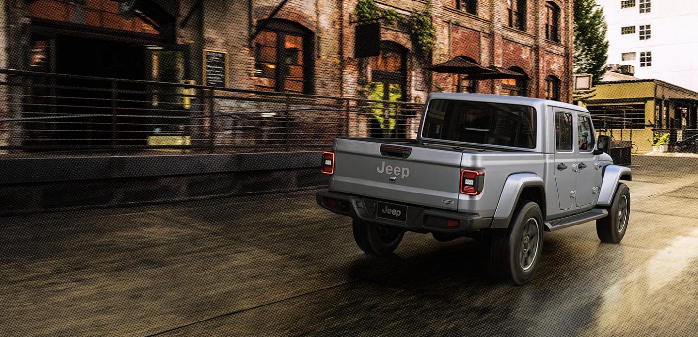 Grey gladiator driving on a rainy street