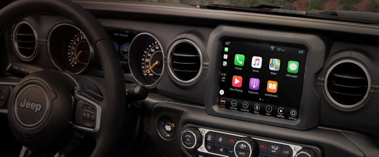 The interior of the 2020 Jeep Wrangler Sahara showing the steering wheel and available 8.4-inch touchscreen.