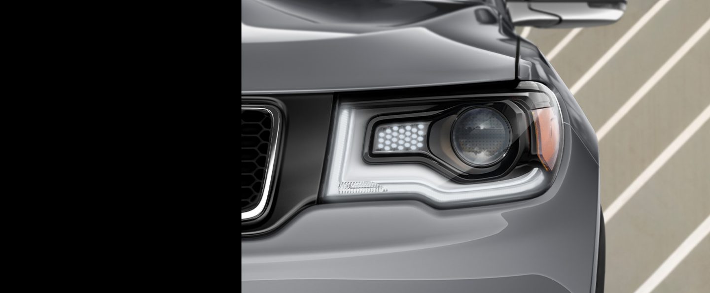Close-up of one of the headlamps, LED strips and Daytime Running Lamps on the 2020 Jeep Compass High Altitude.