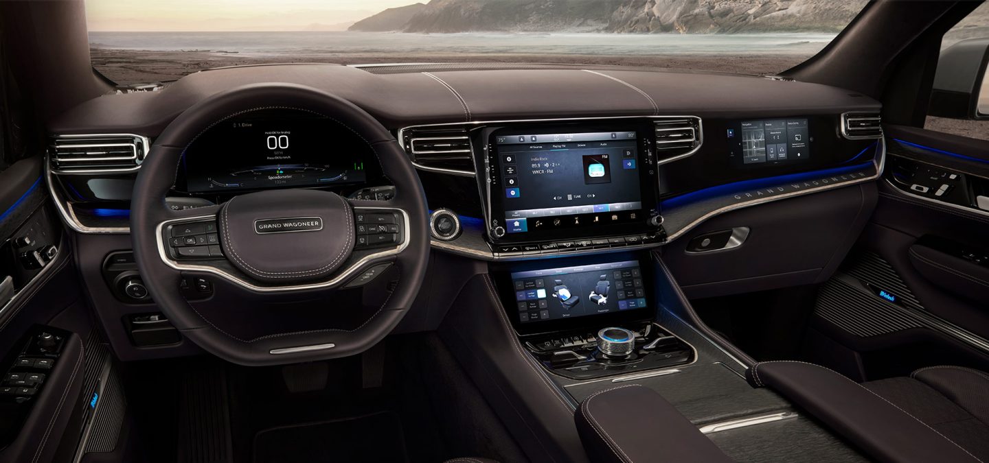 Sweeping view of the instrument panel and dash in the Grand Wagoneer concept, highlighting the metal framing, cluster display and dual touchscreens.